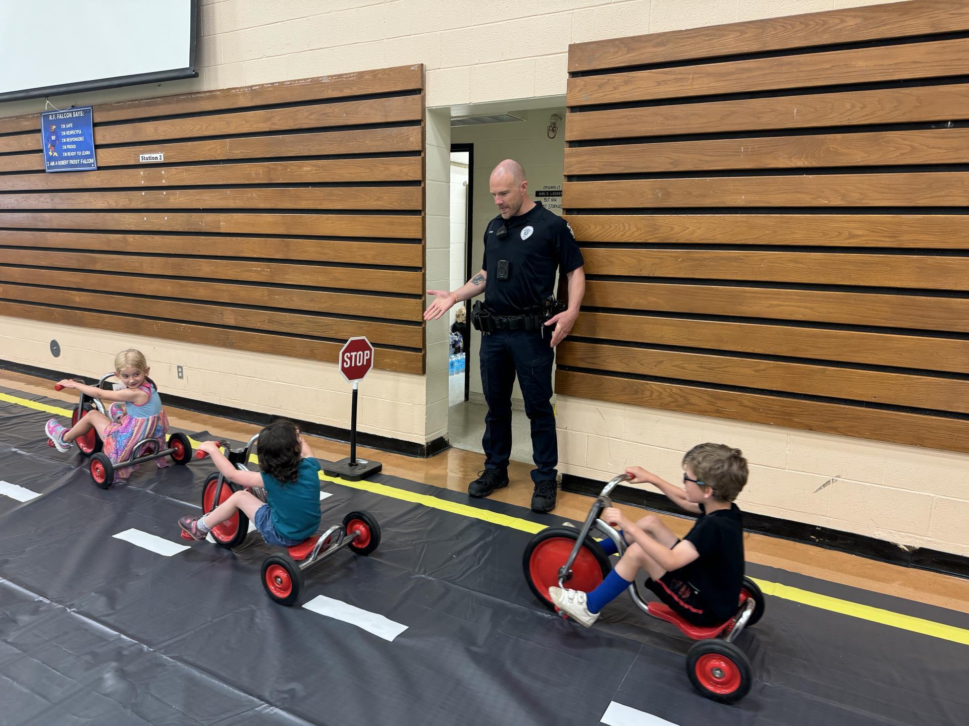 Officer talking to kinds on town