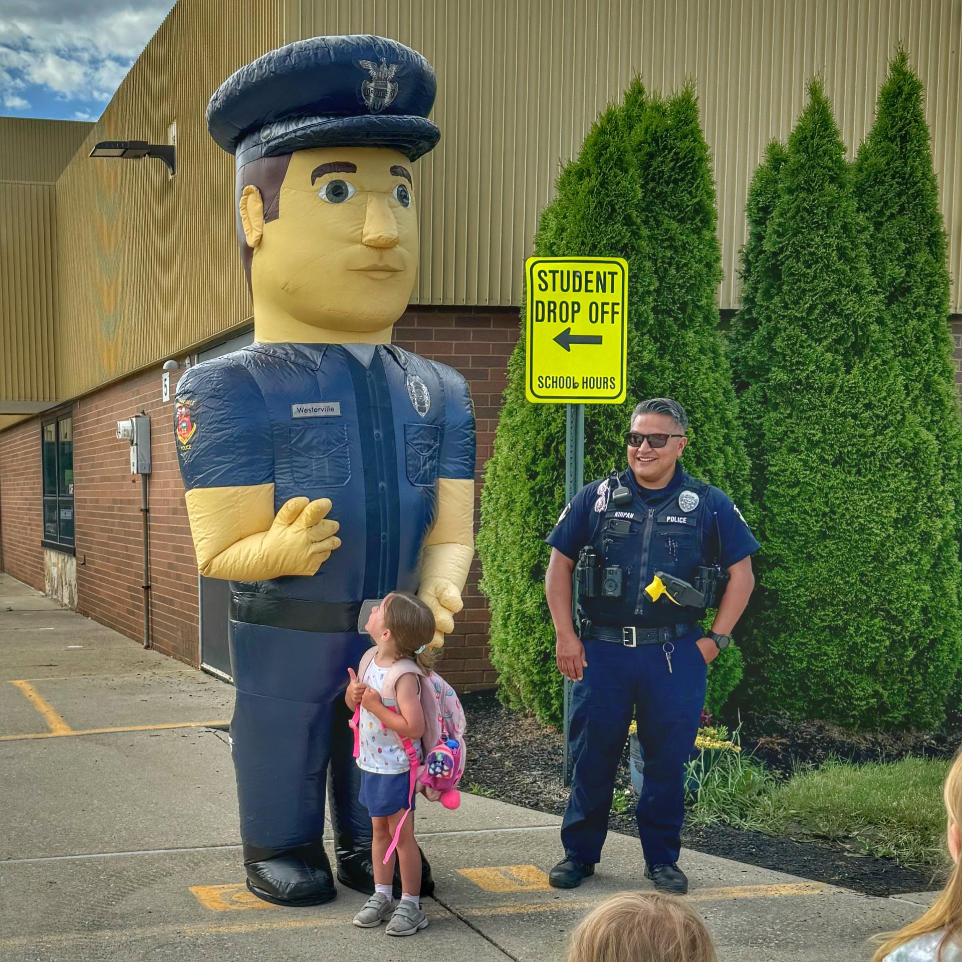 Officer Big Man next to officer and little girl